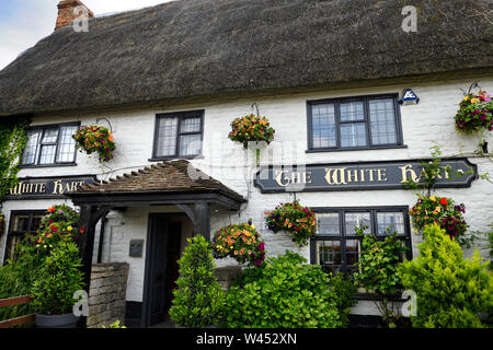 Fassade des White Hart Pub und Inn in Wroughton England mit Blumengarten und Strohdach Stockfoto