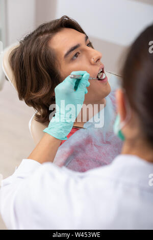 Entspannt junge Patienten in einem behandlungsstuhl Sitzen Stockfoto