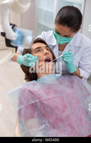 Dunkelhaarige Frau Arzt in einem weißen Labormantel Stockfoto