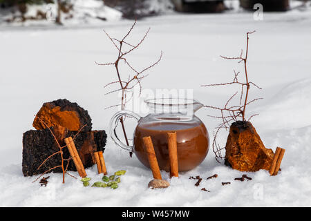 Ein unscharfer winterliche Landschaft hinter frisch gebrühten chaga Chai Tee gesehen wird, eine traditionelle Pilz, Spice & Schokolade trinken mit Kopie Raum nach oben Stockfoto