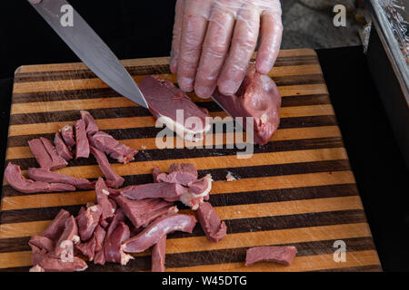 Ein Blick auf die Hände eines Kochs slicing Foie gras, ein luxuriöses Essen gemästet Entenleber, frischen Essen auf einem Stand während eines landwirtschaftlichen Messe verkauft. Stockfoto