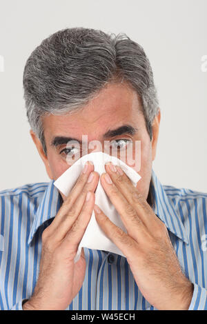 Geschäftsmann bläst Nase mit Taschentuch Stockfoto