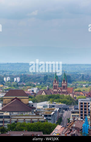 Deutschland, Straßenbahnschienen und Kirche des heiligen Herzens in Freiburg im Breisgau. Stockfoto