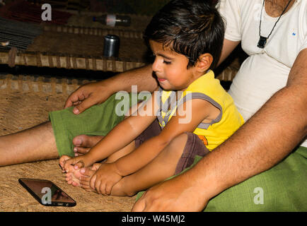 Punjab, Pakistan-May 29,2019: ein smart phone süchtig Little Boy Spiele Spielen auf Smart Phone, einen drei Jahre alten Pakistanischen Kind mittels Smart Phone. Stockfoto