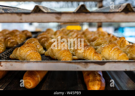 Frisch gebackene Croissants auf Kühlung Rack in Blätterteig Factory Stockfoto