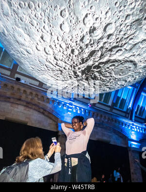 London, Großbritannien, 19. Juli 2019. Die Besucher des Natural History Museum stellen neben einem Modell des Mondes. Der lunar Ausstellung war besonders Bevölkerung Stockfoto