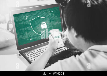 Netzwerk Internet Geräte Sicherheit und Online Data Security system Technologie. Ein Mann mit Handy Verifizierung Kennwort auf dem Computer Laptop Stockfoto