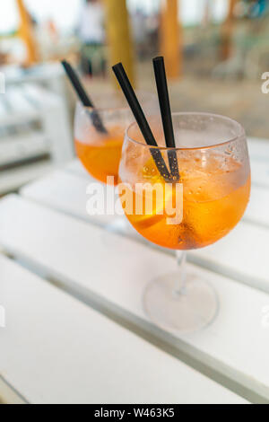 Köstliche classic iced Aperol Spritz Cocktail mit Eiswürfeln an einem heißen tropischen Strand im Sommer Sonnenschein Stockfoto