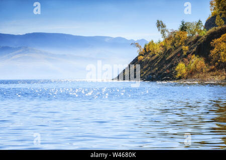 Friedlicher See, Bäume und Berg mit Herbstfarben am Baikal Stockfoto