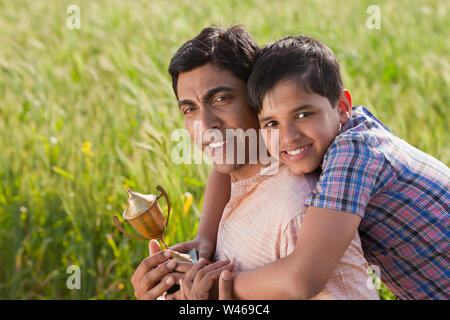 Junge umarmt seinen Vater von hinten Stockfoto