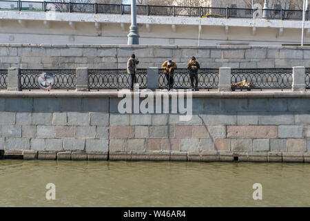 Moskau, Russland, 12. Februar 2019: Streetworker am Flussufer mit einer Metallstange, die Reinigung der Fluss Stockfoto