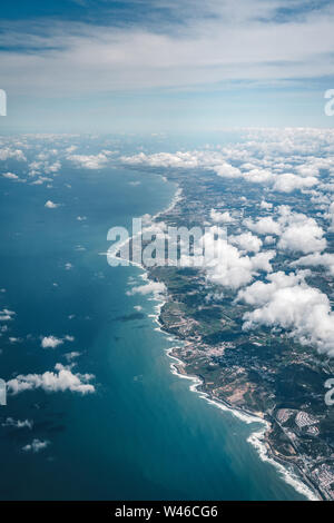 Flug über die Küste von Portugal Lissabon Region. Luftaufnahme durch das Flugzeug Fenster mit Wolken, Wasser und die Küste. Stockfoto