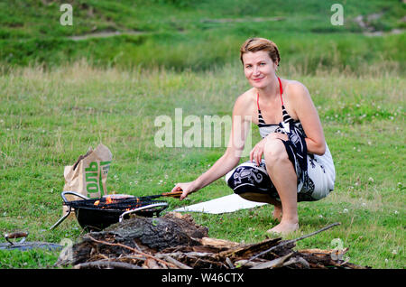 Blonde Mädchen gebackenen Grill in Outing in der Natur niedlich Stockfoto