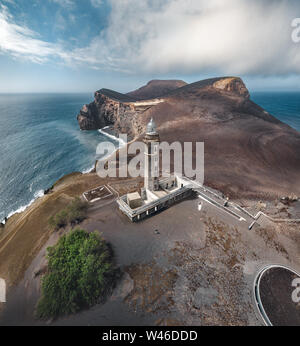 Blick über den Vulkan Capelinhos, Leuchtturm von Ponta Dos Capelinhos auf der westlichen Küste auf die Insel Faial, Azoren, Portugal an einem sonnigen Tag mit blauen Himmel und Stockfoto