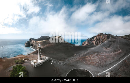 Blick über den Vulkan Capelinhos, Leuchtturm von Ponta Dos Capelinhos auf der westlichen Küste auf die Insel Faial, Azoren, Portugal an einem sonnigen Tag mit blauen Himmel und Stockfoto