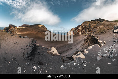 Blick über den Vulkan Capelinhos, Leuchtturm von Ponta Dos Capelinhos auf der westlichen Küste auf die Insel Faial, Azoren, Portugal an einem sonnigen Tag mit blauen Himmel und Stockfoto