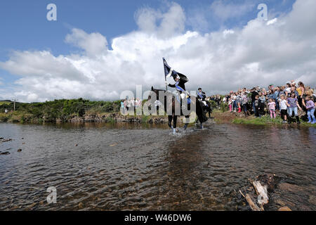 Kelso, Schottland, Großbritannien. Juli 2019 20. Kelso Civic Woche - yetholm Ride Out, Kelso. Kelso Laddie Mark Henderson trägt die Stadt Flagge (Standard), wie Er durchschreitet die Bowmont Wasser vor der 200 starke montiert Kavalkade mit RHM Sean Haken (2018 KL), Craig Logan (2017-KL), auf der Fahrt zu Yetholm Samstag, 20. Juli 2019. (Bild: Rob Grau): Rob Grau/Alamy leben Nachrichten Stockfoto