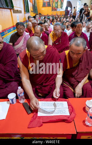 Nepalesische buddhistische Mönche teilen Gebet Bücher zu einem Service an der Sherpa Kyidug Tempel in Elmhurst, Queens, New York City. Stockfoto