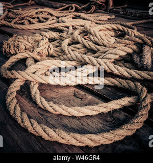 Coarse coconut Seil an der hölzernen Fischerboot Deck unter Sonnenlicht Sonnenuntergang. Detail der chinesischen Fischernetze in Cochin (Kochi). Süd Indien, Kerala, kochin. Stockfoto