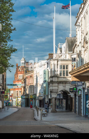 Den Geschäften auf der High Street im Zentrum der Stadt mit den 1596 Granit guildhall Gebäude, Exeter, Devon, England, Großbritannien Stockfoto