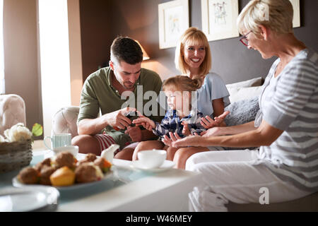 Junge Eltern mit weiblichen Kind besuch Großmutter Stockfoto