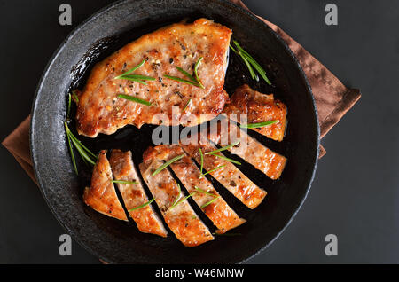 Grill Fleisch. Gegrilltes saftiges Schweinefleisch Steaks mit Rosmarin in der Pfanne, Ansicht von oben Stockfoto