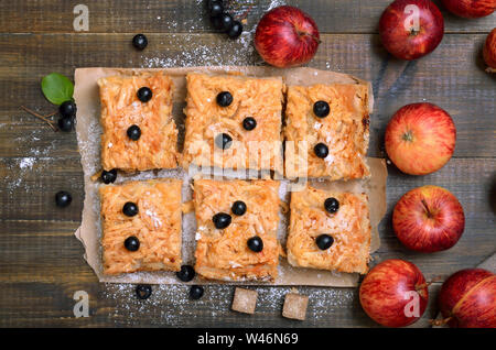 Obst gebackenes hausgemachten Apfelkuchen dekoriert Berry schwarze Apfelbeere und frische Äpfel auf Holz- Hintergrund, Ansicht von oben Stockfoto