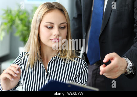 Schöne blonde weibliche Angestellte im Gespräch mit männlichen Kollegen Stockfoto