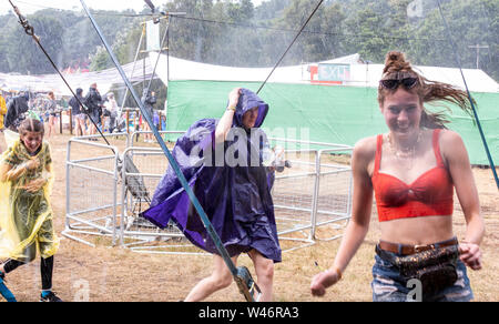 Festivalbesucher laufen für Schutz vor massiven unerwarteter Regenguß, Latitude Festival, henham Park, Suffolk, Großbritannien am 20. Juli 2019 Stockfoto