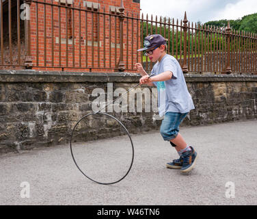 Acht Jahre alten Jungen spielen Altmodische hoop Rollen Spiel, Beamish Museum, County Durham, England, Großbritannien Stockfoto