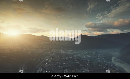 Berg Suburban Stadt Cottage Sunrise Luftaufnahme. Dawn weichen Sonnenlicht Panoramablick auf die Landschaft Dorf Übersicht. Friedliche Nachbarschaft Apartment Blick Tourismus Konzept. Drone Flug Stockfoto