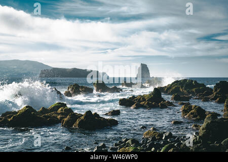 Azoren, große Wellen, die über schwarzen vulkanischen Felsen auf dem Atlantischen Ozean an der Küste der Insel Faial auf den Azoren, Portugal Stockfoto