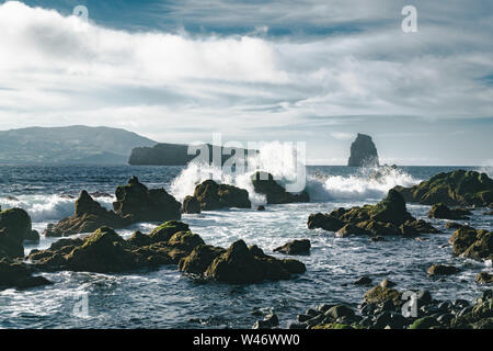 Azoren, große Wellen, die über schwarzen vulkanischen Felsen auf dem Atlantischen Ozean an der Küste der Insel Faial auf den Azoren, Portugal Stockfoto