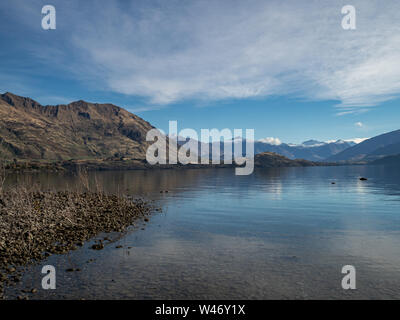 Blick auf den Lake Wanaka und Südlichen Alpen im Herbst mit Schnee auf den Gipfeln und Reflexionen im Wasser Stockfoto