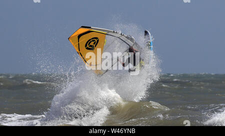 Ein Windsurfer stürzt durch die Wellen bei windigen Bedingungen im Camber, East Sussex. Stockfoto