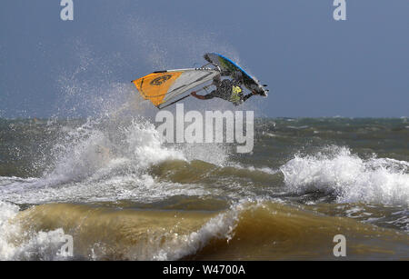 Ein Windsurfer stürzt durch die Wellen bei windigen Bedingungen im Camber, East Sussex. Stockfoto