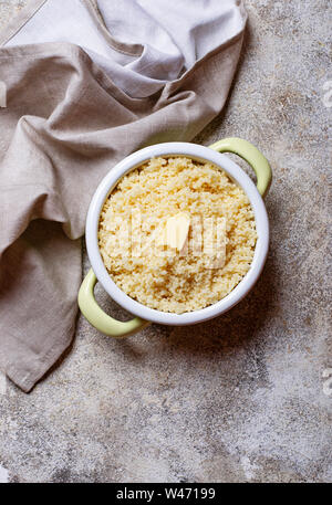 Couscous mit Butter im Topf auf hellen Hintergrund Stockfoto