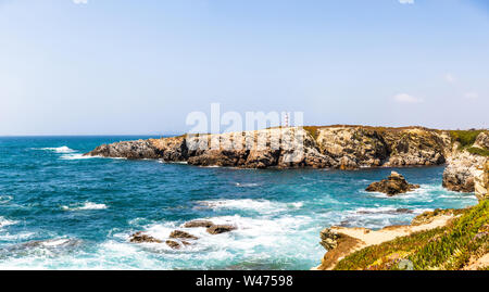 Sicht auf die Klippen und dem Leuchtturm in der Nähe von Praia Pequena Strand in Porto Covo, Portugal Stockfoto