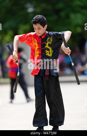 Columbus, Ohio, USA - 26. Mai 2019: Columbus asiatischen Festival, Franklin Park, Junge mit Nunchakus, das Tragen der traditionellen Kleidung Stockfoto