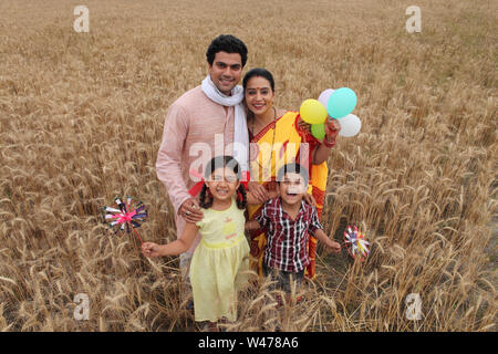 Ländliche Familie stehen und Lächeln in einem Feld Stockfoto