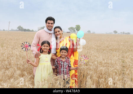 Ländliche Familie stehen und Lächeln in einem Feld Stockfoto