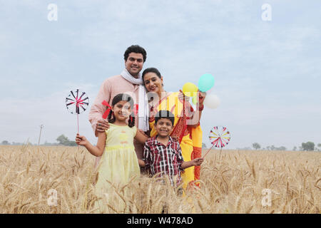 Ländliche Familie stehen und Lächeln in einem Feld Stockfoto