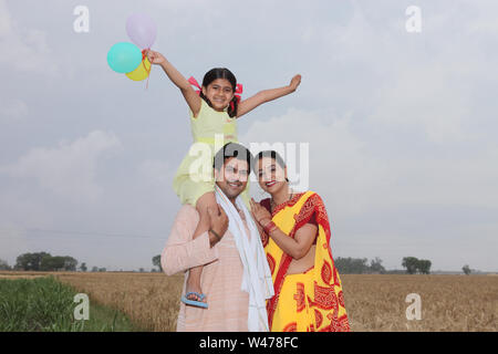 Porträt einer Familie, die auf einem Feld lächelt Stockfoto