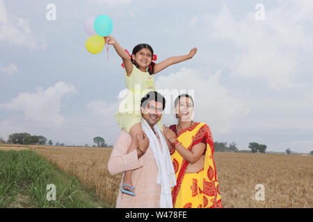 Familie lächelt auf einem Feld Stockfoto