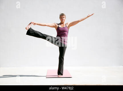 Reifer senior Frau practing Sanfte restorative Yoga in weißem Hintergrund fotografiert. Stockfoto