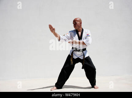 Black Belt Sensei Kampfkunstausbilder demonstrieren Taekwondo bilden. Er ist ein Meister und Ausbilder wie durch seine Uniform und Form bezeichnet. Stockfoto