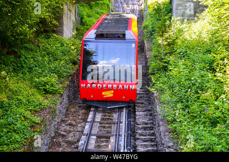 Interlaken, Schweiz - 16. Juli 2019: rote Seilbahn fahren bergab vom Harder Kulm, oben von Interlaken. Die Seilbahn fährt nach oben und unten von Touristen beliebt. Transport, Tourismus. Stockfoto