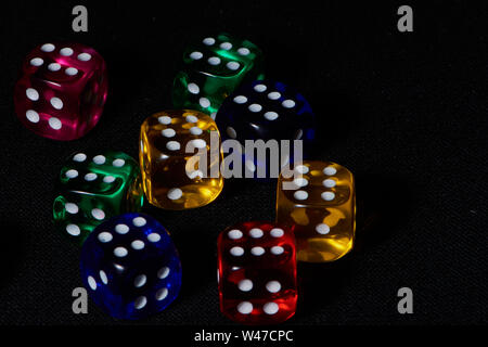 Makro von acht farbigen Würfel mit den Abbildung 6 auf schwarzem Hintergrund Stockfoto