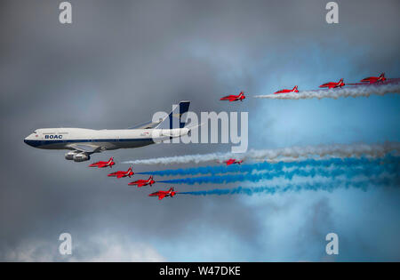 RAF Fairford, Glos, Großbritannien. Juli 2019 20. Tag 2 des Royal International Air Tattoo (RIAT) mit militärischer Flugzeuge aus der ganzen Welt Montage für größte Airshow der Welt mit einem vollen Flying Display bei gutem Wetter. Bild: Flypast durch die RAF Red Arrows aerobatic Display Team in Formation mit einem Livrierten BOAC Boeing 747. Credit: Malcolm Park/Alamy Leben Nachrichten. Stockfoto