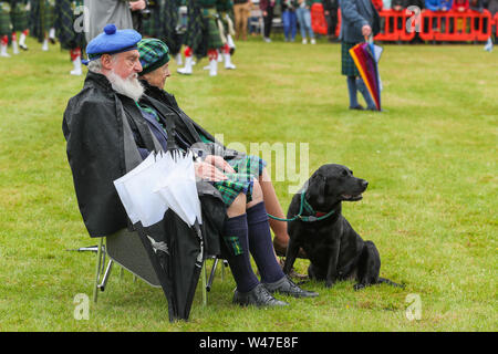 Tomintoul, Schottland. 20. Juli 2019 eines der wichtigsten Highland Games Sammlung begann mit dem traditionellen Umzug der lokalen Pipe Bands durch die Stadt von Tomintoul und bedankte sich bei den Einheimischen an mehreren Haltestellen auf dem Weg, ein dram der lokalen Scotch Whisky zu jedem Mitglied der Bands. Trotz starker Regen, die Spiele weiterhin Unterhaltung auf Tausende von Zuschauern und viele Touristen aus dem Ausland Stockfoto